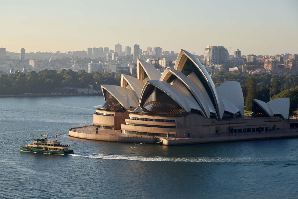 A view of the Sydney Opera House as a ferry passes in the morning light