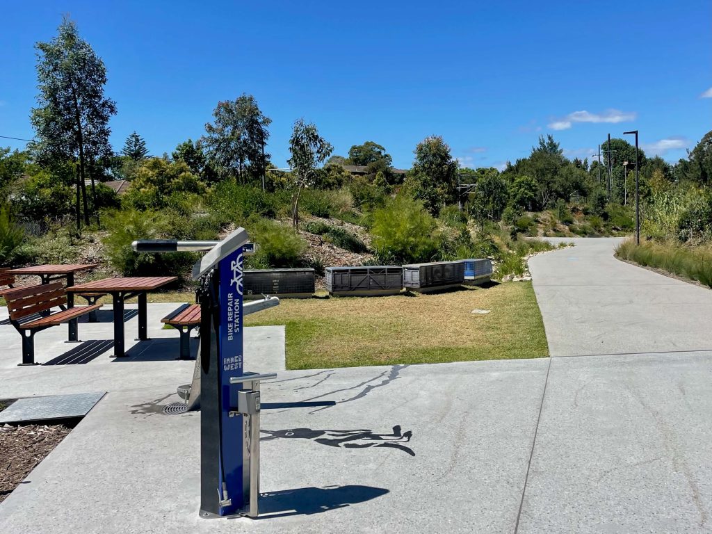 Near the Hercules Street Creek Line on the GreenWay: seating, water fountain, bike repair station, and art alongside the path